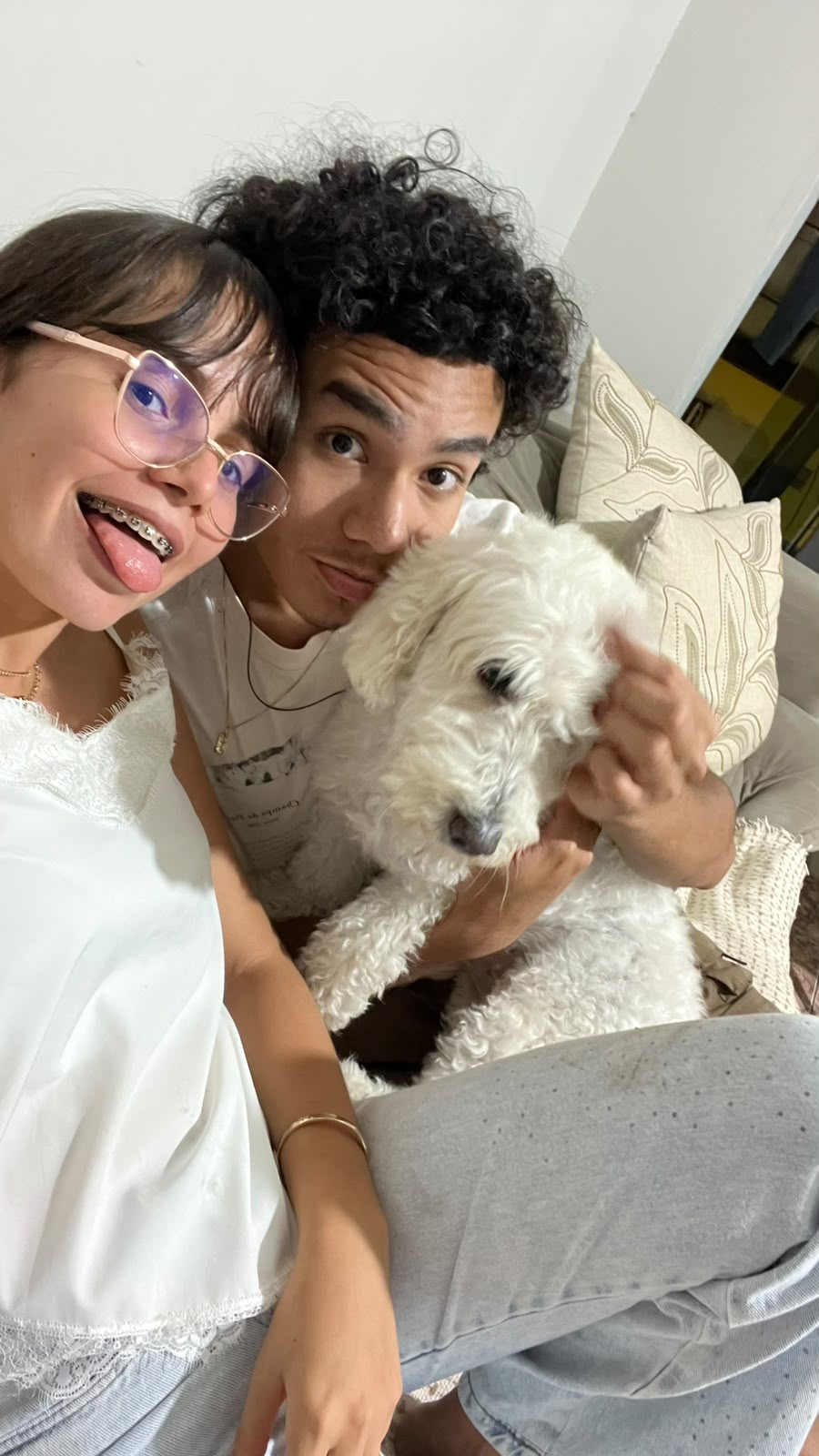 Jennifer, uma pessoa importante e um cachorro branco no sofá